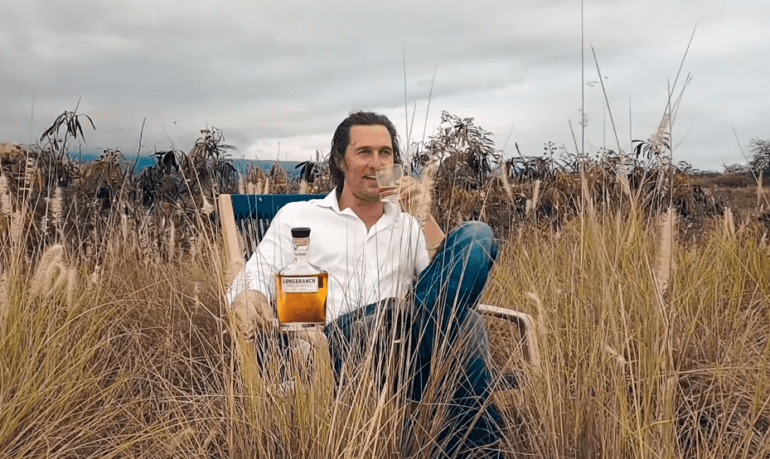 Matthew McConaughey sitting in a field