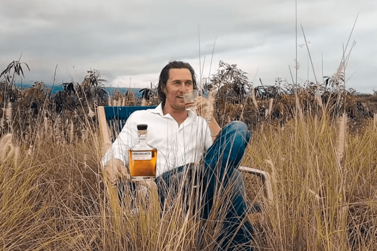 Matthew McConaughey sitting in a field