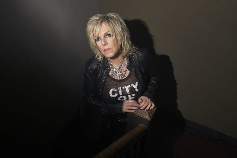 Lucinda Williams sitting on a chair