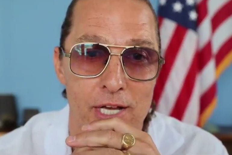 Matthew McConaughey with glasses and a white shirt with a gold ring on his chin