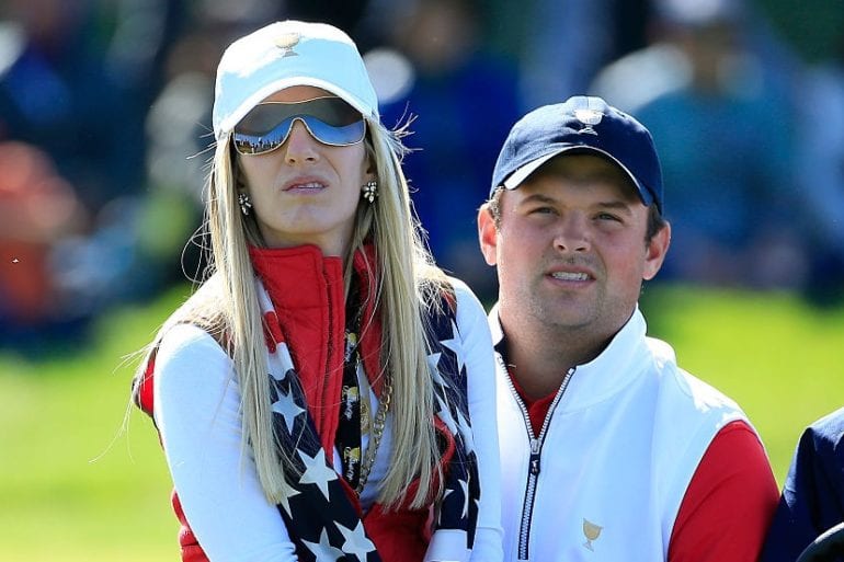 Patrick Reed and woman wearing white shirts and blue hats