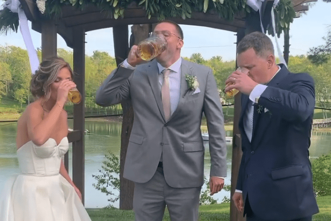 A person in a suit drinking from a glass