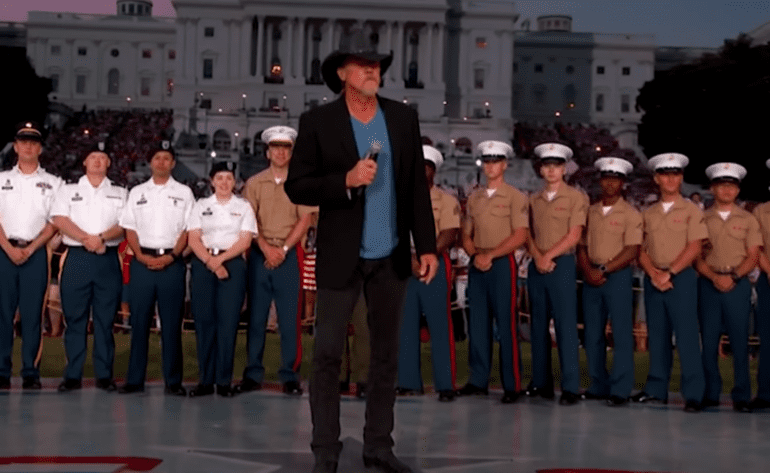 Trace Adkins standing in front of a group of people in uniform