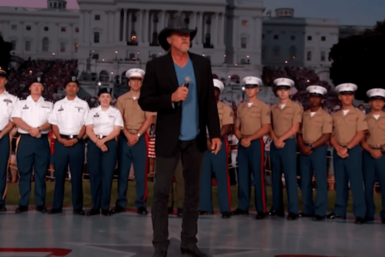 Trace Adkins standing in front of a group of people in uniform