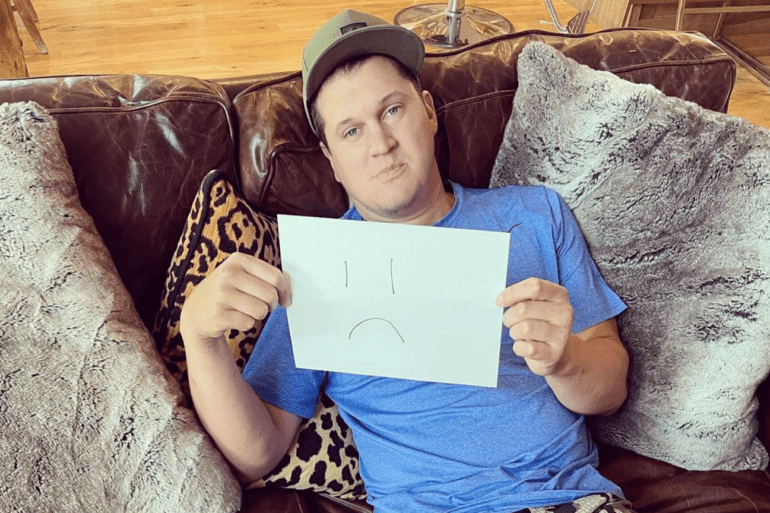 Jon Pardi sitting on a couch holding a tablet