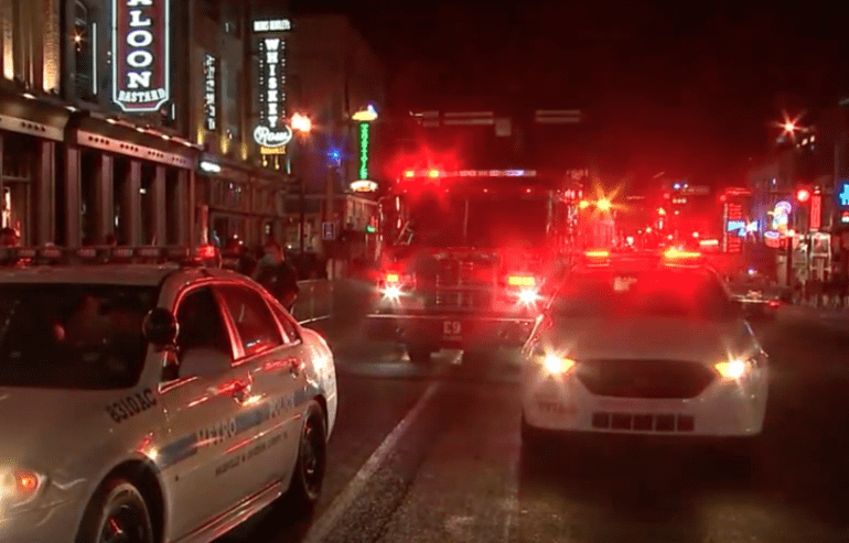 A group of emergency vehicles on a street at night