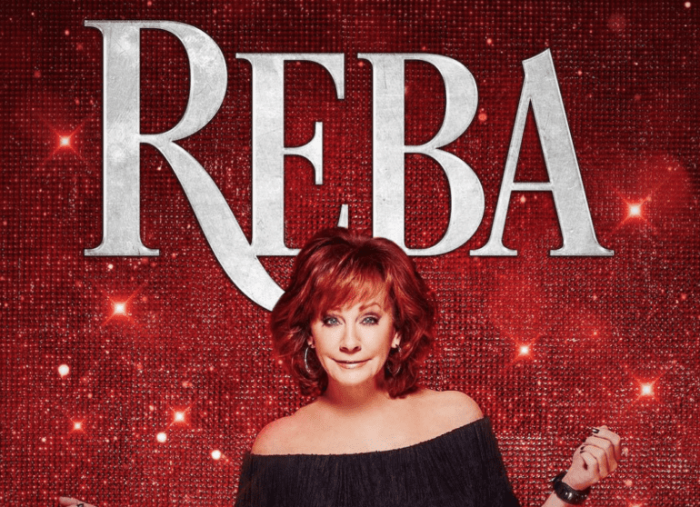 Reba McEntire with the hand out in front of a sign