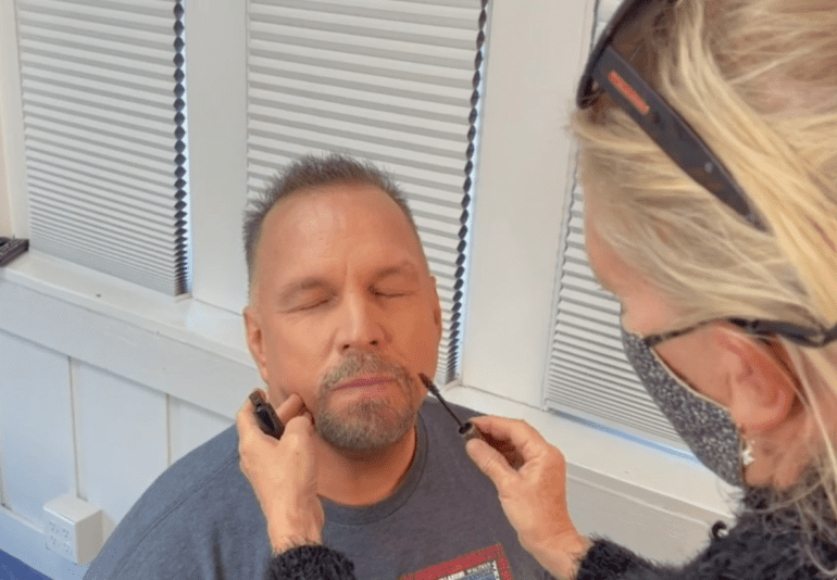Garth Brooks with a beard talking on a cell phone