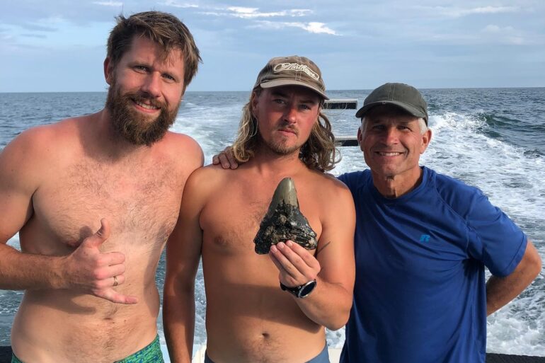 A group of men posing for a picture on a beach