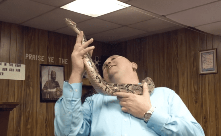 A person holding a snake