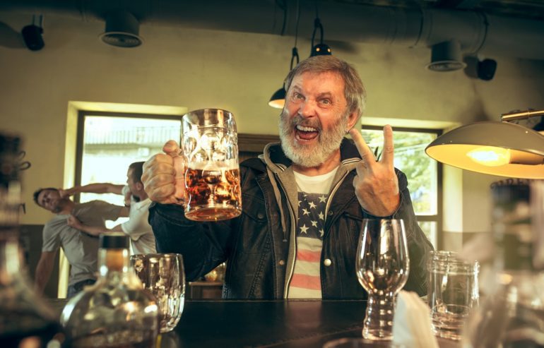 A man holding up a couple of glasses of wine
