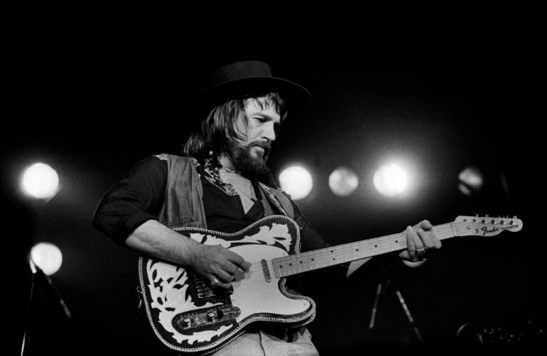 Waylon Jennings playing a guitar
