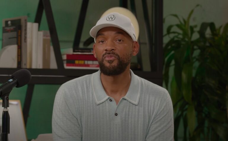 Will Smith wearing a white hat and a white shirt in front of a microphone