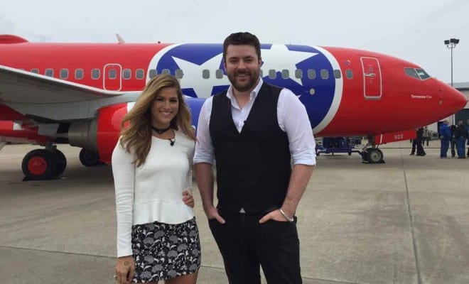 Chris Young and woman standing in front of a plane
