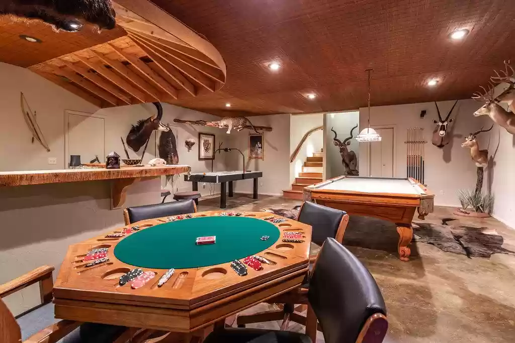 A room with a pool table and chairs