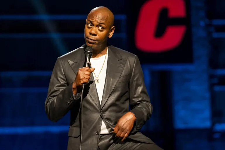 Dave Chappelle speaking into a microphone