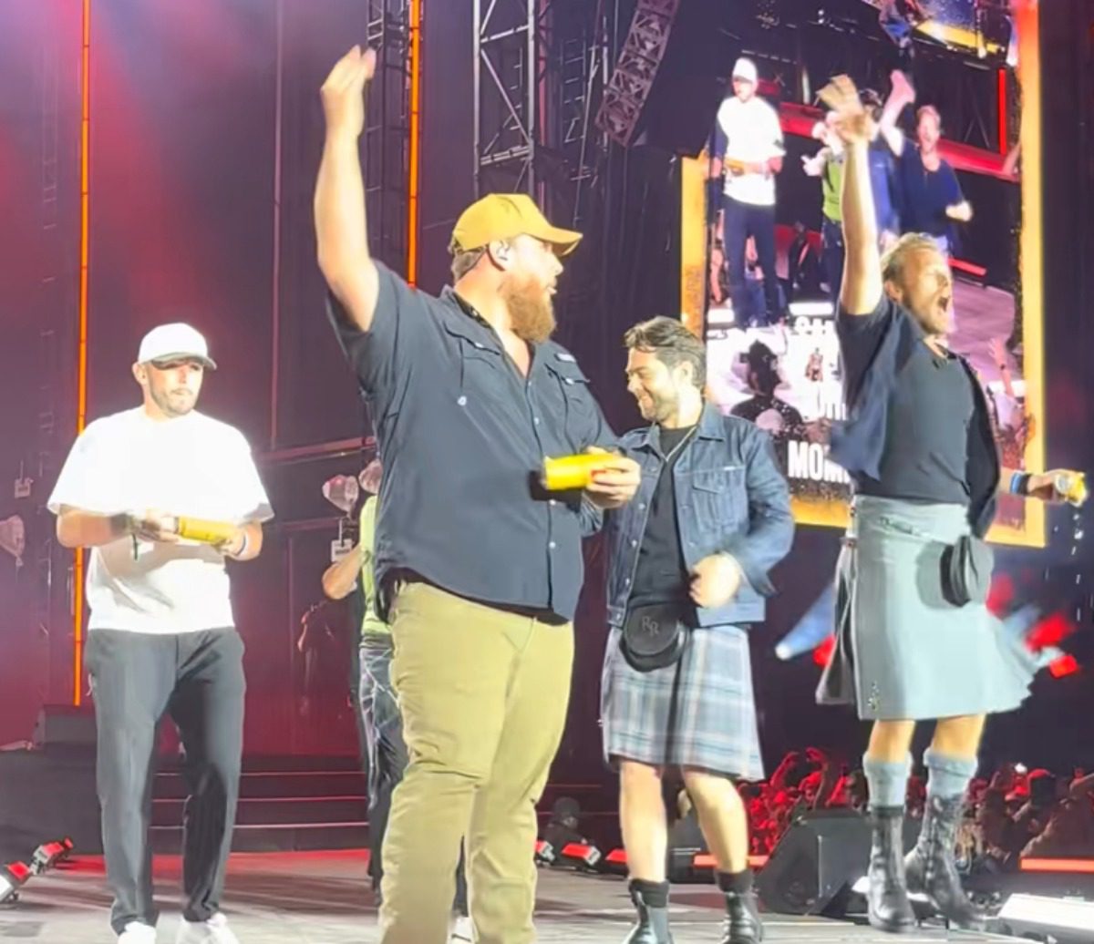 Luke Combs Brings ‘Outlander’ Star Sam Heughan On Stage To Shotgun A Beer In Scotland