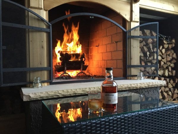 A bottle of alcohol in front of a fireplace