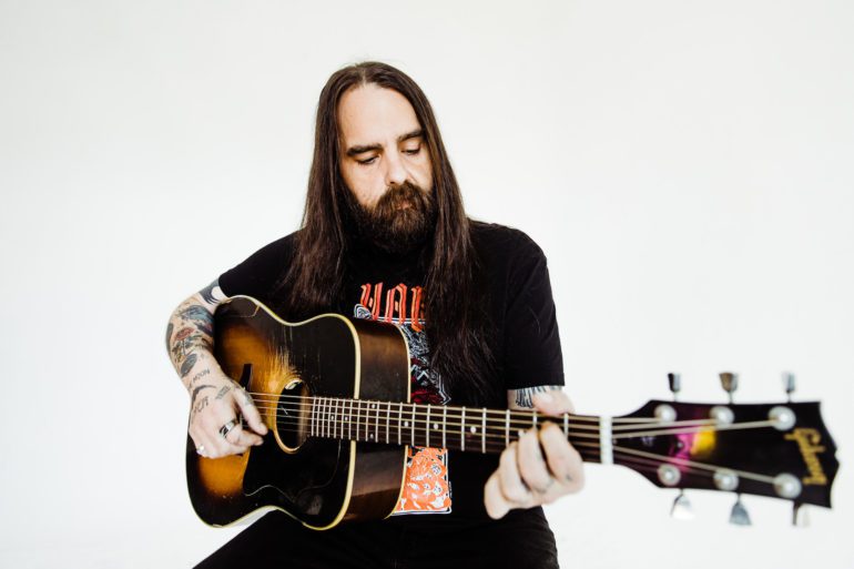 A person with long hair playing a guitar